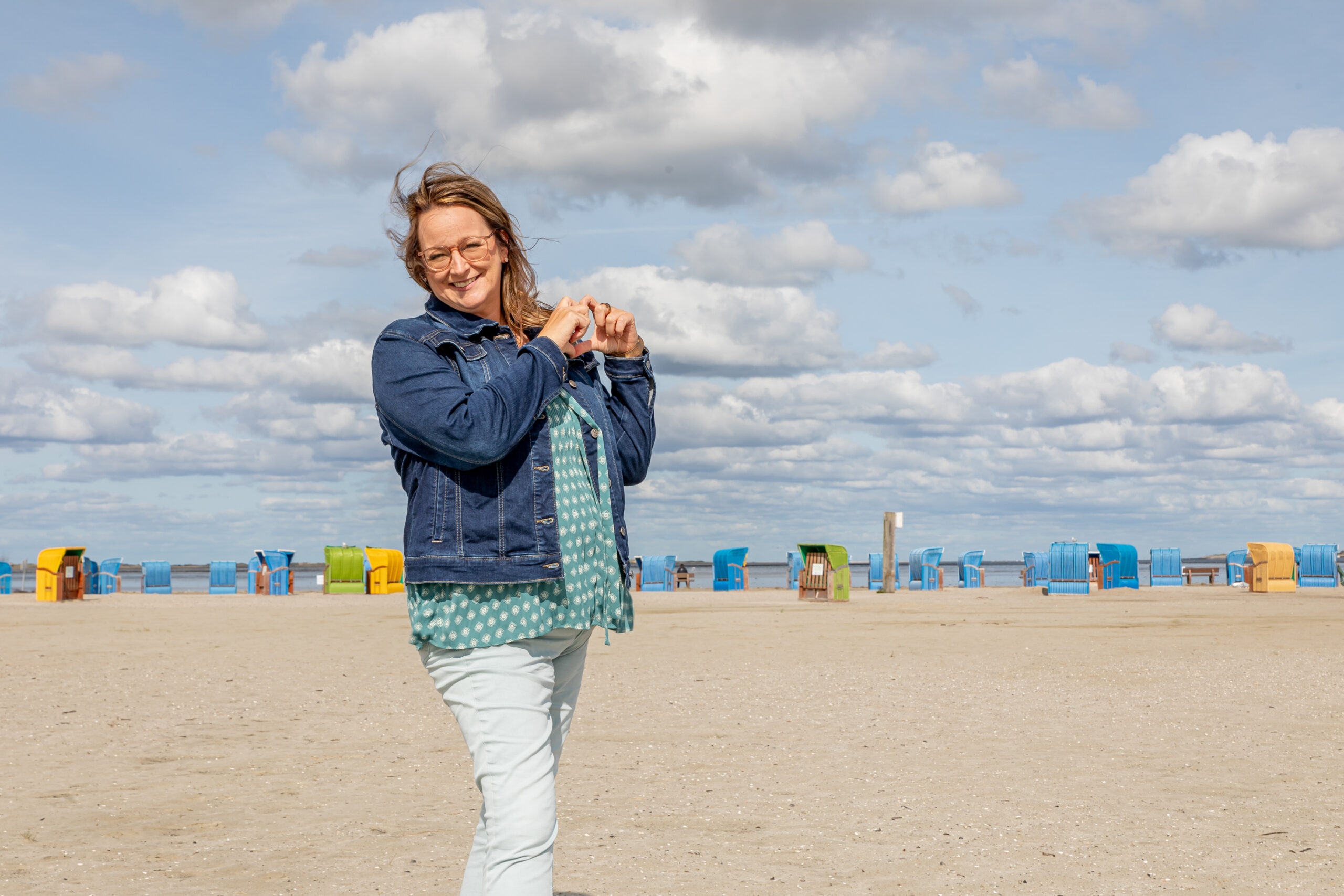 Perfektionismus lösen, Sonja Kleene am Nordseestrand, formt ein Herz mit ihren Händen